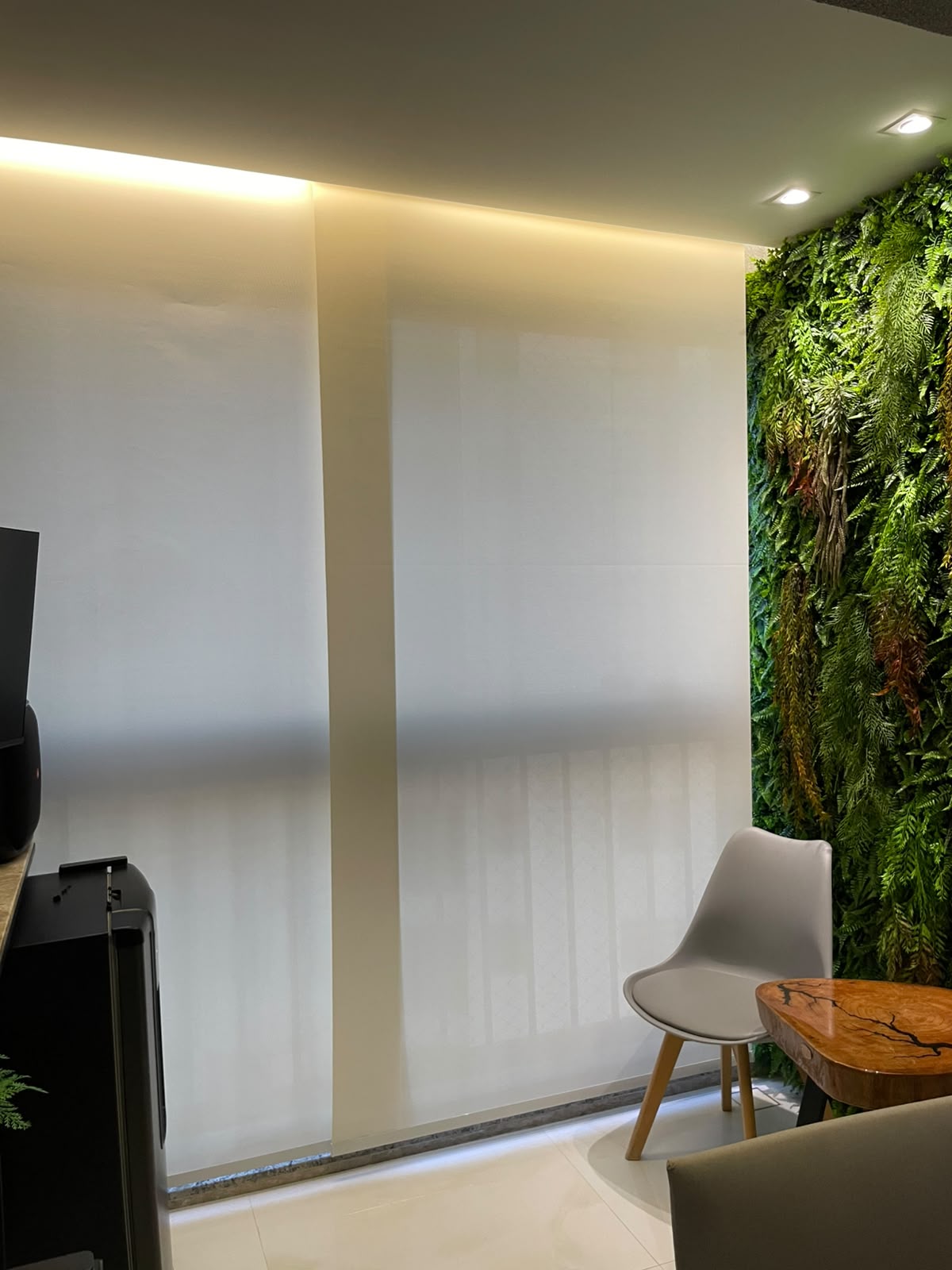 Persiana rollo tela solar em ambiente corporativo com parede verde